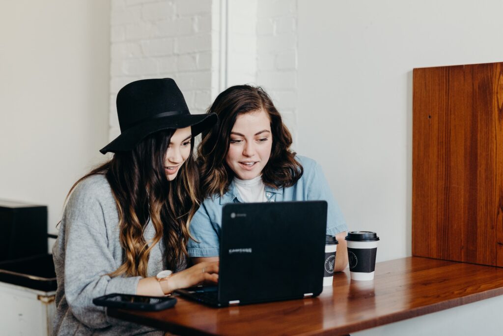Educational content helps customers, like the two smiling women seated in front of a laptop in this image, learn things of practical value. It also helps customers become more aware of business brands and helps  customers feel meaningfully connected with business brands.
